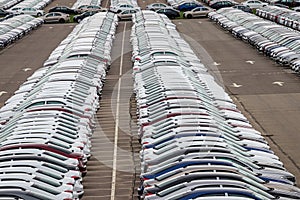 Rows of a new cars parked in a distribution center on a cloudy day in the spring, a car factory