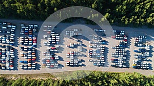 Rows of new cars in the parking lot. Aerial view of large parking lot full of cars of various colors