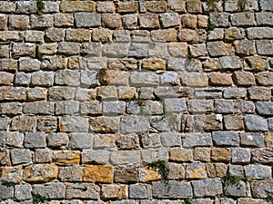 Rows of old stone blocks in an ancient wall. Taken on a sunny day
