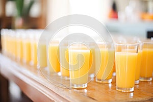 rows of orange juice glasses for brunch event
