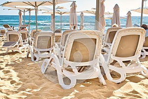 Rows of plastic beach recliners on the beach at a seaside hotel resort