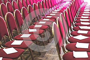 Rows of red chairs in conference hall, empty meeting or event room. Empty guest seats