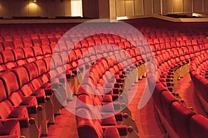 Rows of red cinema seats. View of empty theater hall. Comfort chairs in the modern theater interior