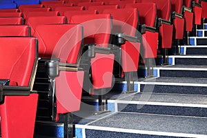 Rows of red seats and grey stairs in auditorium