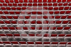 Rows of red seats on the stadium. Empty red plastic chairs