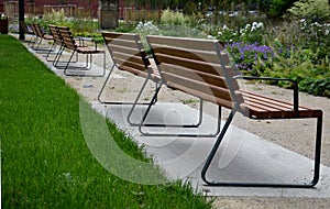 Rows of reddish wood benches on their paneling under the benches is a rectangle of concrete anti-scraping beige paths by the shoes