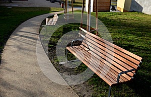 Rows of reddish wood benches on their paneling under the benches is a rectangle of concrete anti-scraping beige paths by the shoes