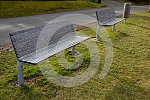 Rows of reddish wood benches on their paneling under the benches is a rectangle of concrete anti-scraping beige paths by the shoes