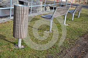 Rows of reddish wood benches on their paneling under the benches is a rectangle of concrete anti-scraping beige paths by the shoes