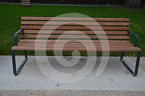 Rows of reddish wood benches on their paneling under the benches is a rectangle of concrete anti-scraping beige paths by the shoes