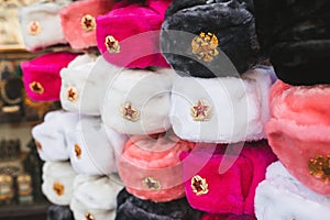 Rows of russian winter hats of different colors with army emblems at the street market iconic popular souvenir from