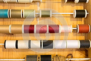 Rows of sewing color threads frame on wooden table