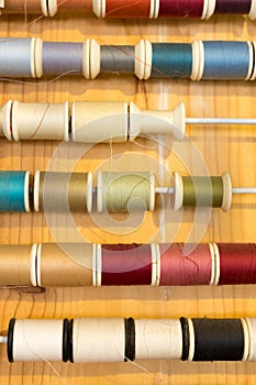 Rows of sewing color threads frame on wooden table