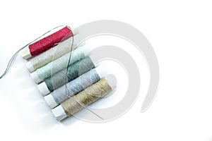 Rows of sewing threads of various colors and sewing needles isolated on white