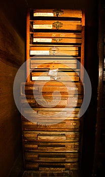 Rows of shelfs containing moveable type and letterpress tools.