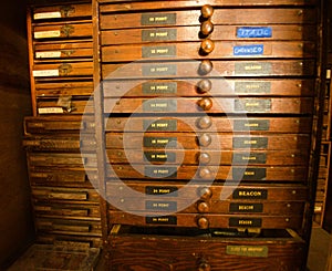 Rows of shelfs containing moveable type and letterpress tools.