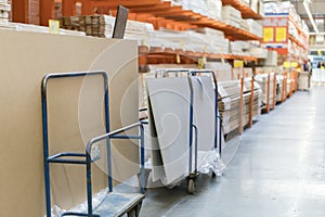 Rows of shelves with boxes and storage carts in modern warehouse