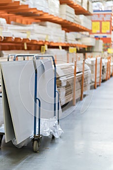 Rows of shelves with boxes and storage carts in modern warehouse