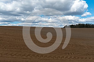 Rows of soil before planting. Drawing of furrows on a plowed field prepared for spring sowing of agricultural crops. View of the