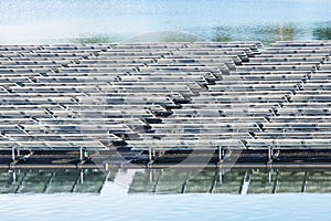 Rows of solar cells or photovoltaics on the water in power station lake