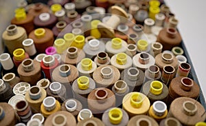 Rows of spools of thread of different colors in a box in the studio