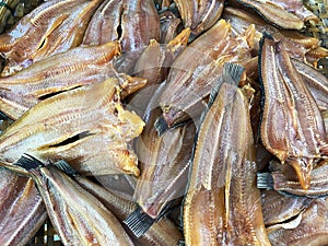 Rows of sun-dried snakehead fish displayed on the tray at a local market