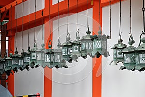 Rows of traditional bronze lanterns hanging in Kasuga Taisha Shrine