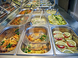 Rows of trays with fresh ready food in a Russian cuisine canteen