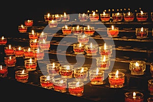 Rows of votive candles in a Catholic church.