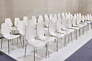 Rows of white chairs in presentation room