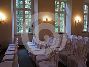 Rows of white chairs in wedding hall