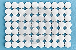 Rows white medical pills on blue background, pharmaceuticals, medical, and chemistry