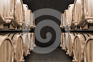 Rows of wine or beer kegs in black brick cellar