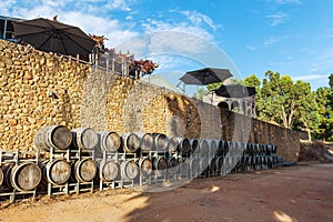 Rows of wooden wine barrels in vineyard in Australia.