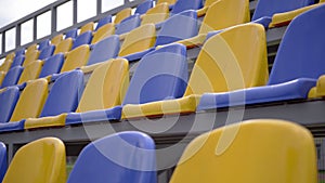 Rows of Yellow and Blue Plastic Seats On Empty Tribune of  Stadium, 4k