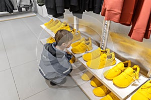 Rows of yellow Sneakers, boy look on shoes