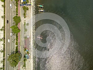 Roxas Boulevard and boardwalk. Top view of Manila Bay. A few outrigger boats moored on the breakwater photo
