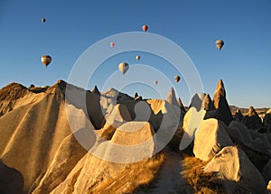 Royal ballons flying in the sunrise light in Cappadocia, Turkey above the Fairy ChimneysÃÂ rock formationÃÂ nearby Goreme