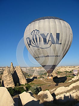 Royal ballons flying in the sunrise light in Cappadocia, Turkey above the Fairy ChimneysÃÂ rock formationÃÂ nearby Goreme