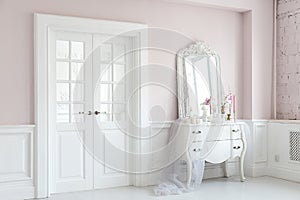 Royal bedroom. Place for make-up girls. Elegant white dressing table with mirror in light classic luxury interior.