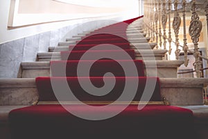 Marble stairways covered with red carpet photo