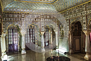 Royal City Palace Jaipur interior view of glass room with mirror and gold artwork at Rajasthan, India