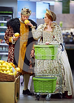 Royal couple, supermarket and king with queen, conversation and shopping with increase. Smelling, store and man with