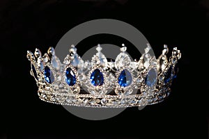 Royal crown with sapphire on black background