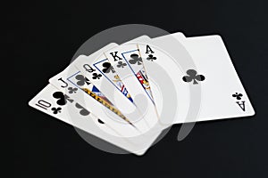 Royal Flush of clubs in poker cards game on a black background