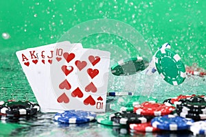 Royal Flush combination under the water drops against green background. Online gambling. Betting.