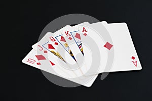 Royal Flush of diamonds in poker cards game on a black background