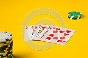 Royal Flush. Five playing cards - the poker royal flush hand. Poker chips on yellow. success in gambling.
