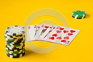 Royal Flush. Five playing cards - the poker royal flush hand. Poker chips on yellow. success in gambling.