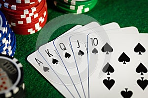 Royal flush in poker game. cards with casino chips on green cloth